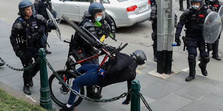 Policia qëllon plumba gome ndaj protestuesve që kundërshtojnë vaksinimin e detyruar në Australi 48202461 10016021 A demonstrator is sent flying backwards off his bike as scenes t a 30 1632302154152 750x375 1