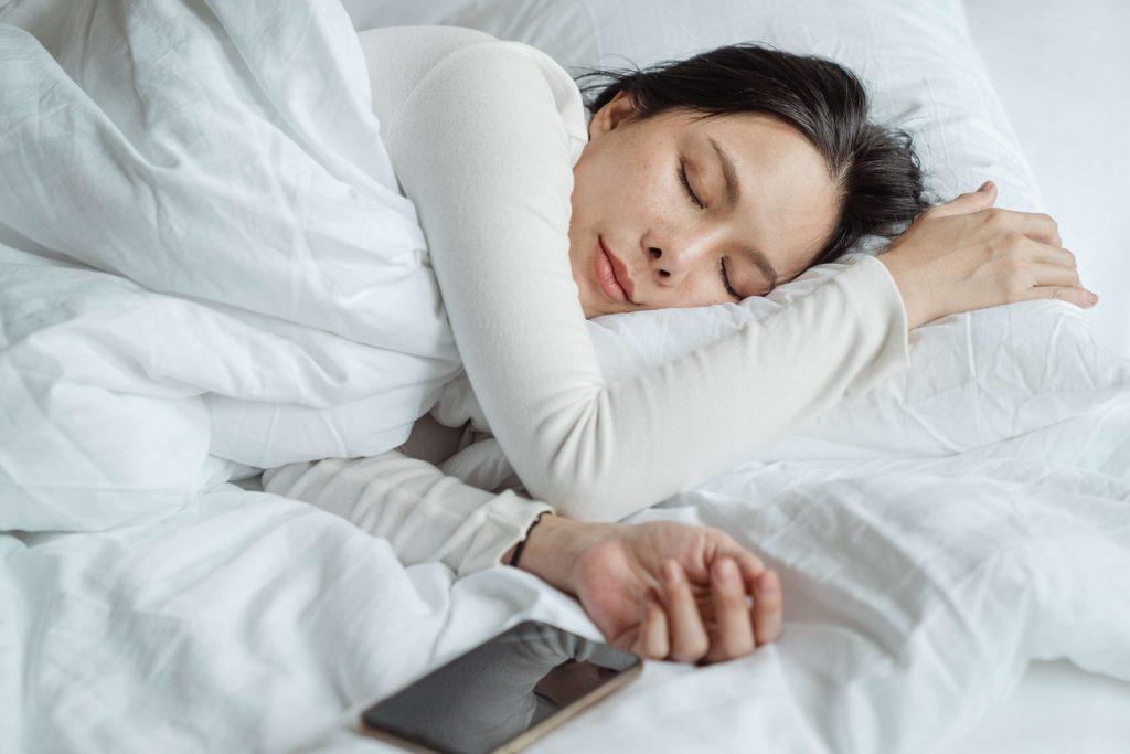 Çfarë do të ndodhë nëse vazhdoni të flini me celularin pranë kokës? Phone in bed 1 Pexels 09 11 22 scaled 1